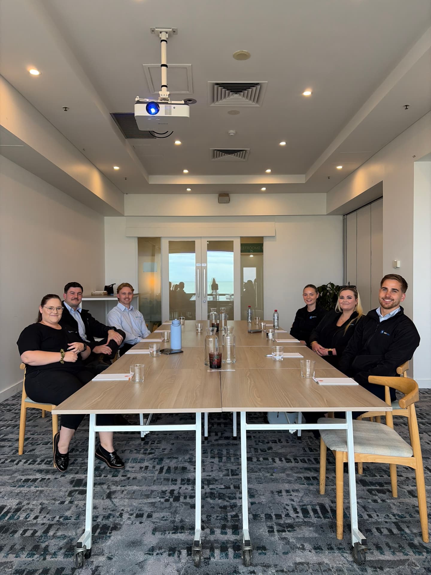 The New Era team seated together around the boardroom table during a team meeting