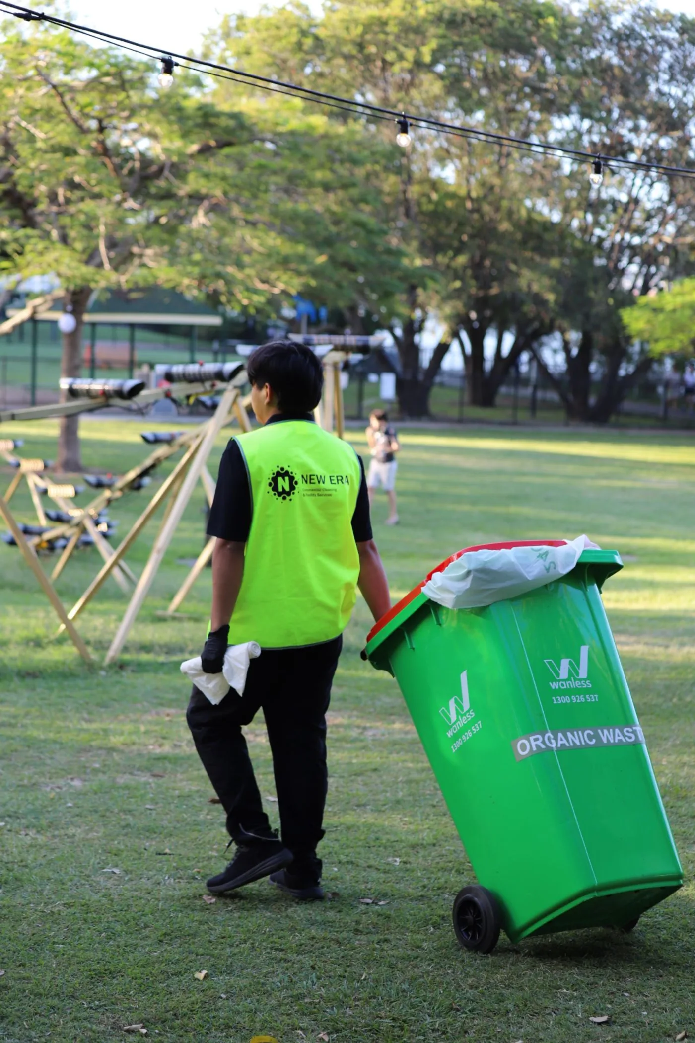 New Era team member moving an organic waste bin during a resource recovery round at an outdoor event